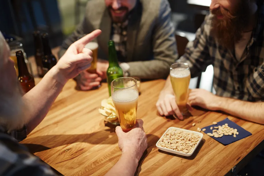 Friends with beer at a wooden table in a pub