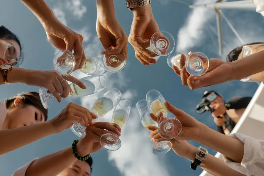 Seen from below: glasses raised against a blue sky