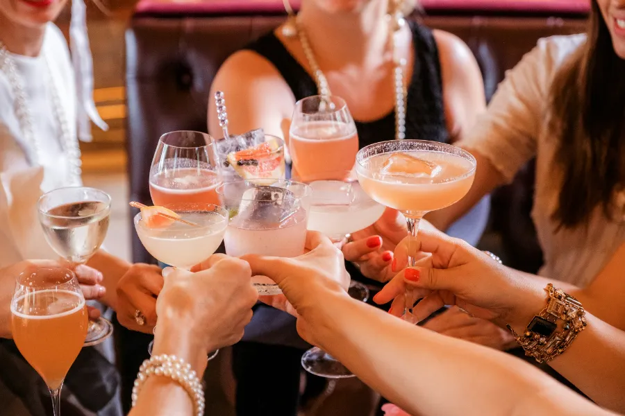 Several cocktail glasses meeting over a table